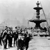 Crowd posing around fountain on Victoria square, in front of Town Hall in April 1902. This photo shows one of the many changes that have been made to the square in front of the Town Hall. A statue of the Duke of Wellington was put up in the square in 1855; a statue of Sir Robert Peel which originally stood outside the old Post Office in Park Row was moved to the front of the Town Hall in the 1890's