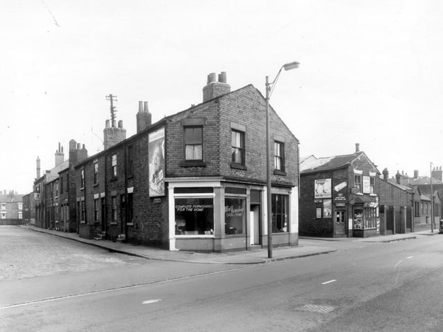 The even numbered side of Dawson Street run from the left edge of this view in descending order. Number 10 Elland Road is at the end of this view in descending order. Number 10 Elland Road is at the end of this row and is a furniture store, Ultra Furnishings. New Princess Street follows to the right, then J. Miller, grocer and general dealer at number 8 Elland Road with Holbeck Sorting Office on the right edge. Pictured in April 1959.