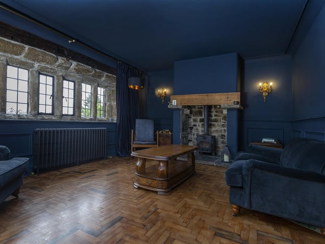 A parquet floor and multi-fuel stove within the stone fireplace are features of this comfortable room.
