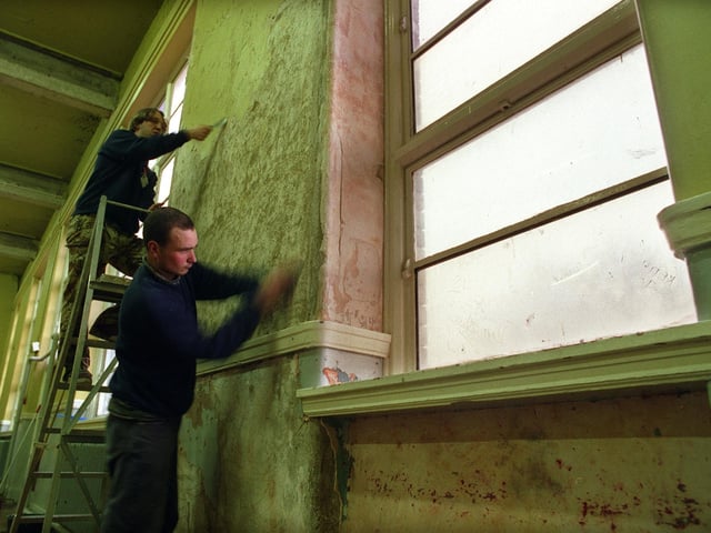Ian Simpson, top, and Nigel Binks at work stripping paint off the walls at South Gipton Community Centre in February 1998.