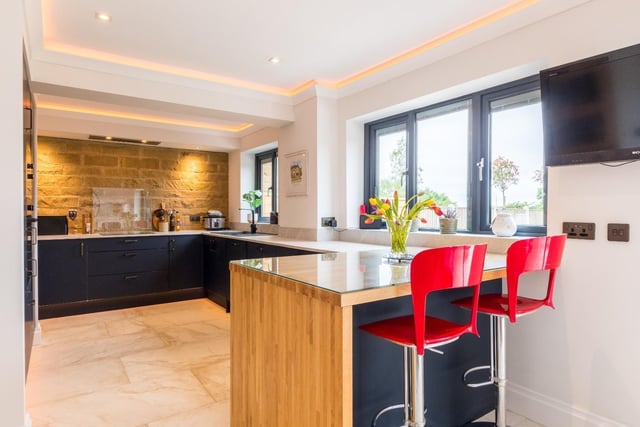 A carefully designed open plan kitchen-diner features built in appliances, mood lighting, blinds and a feature radiator.