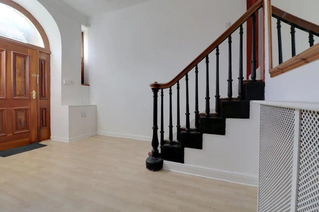An impressive staircase leads from the hallway to the main living space on the first floor.