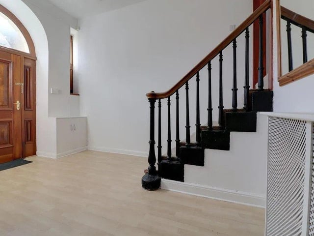 An impressive staircase leads from the hallway to the main living space on the first floor.