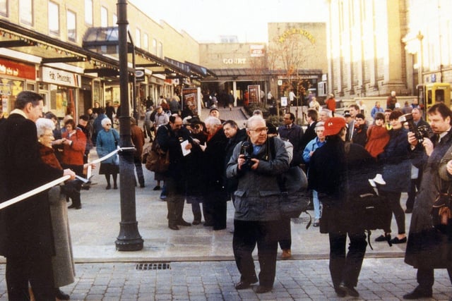 Crowds are gathered on Queen Street and Windsor Court in Morley at the opening of the pedestrianisation scheme for Queen Street. Councillor Linda Middleton, on the left, is about to cut the tape. Pictured in December 1995.