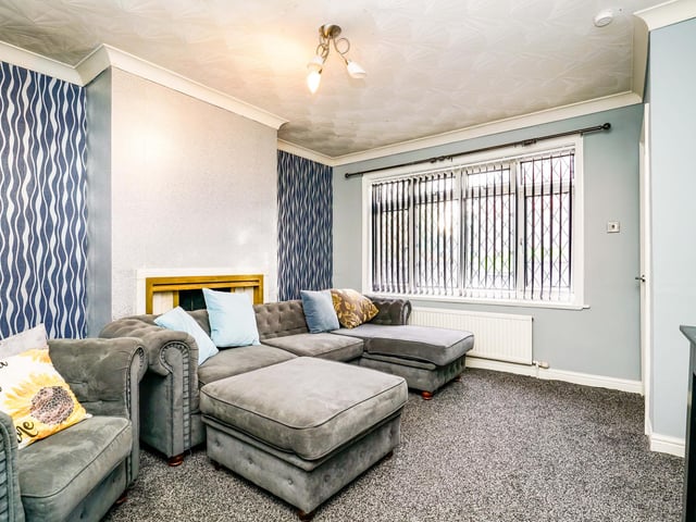 Upon entry, to the right is the spacious living area, backed by the fitted kitchen and utility room.