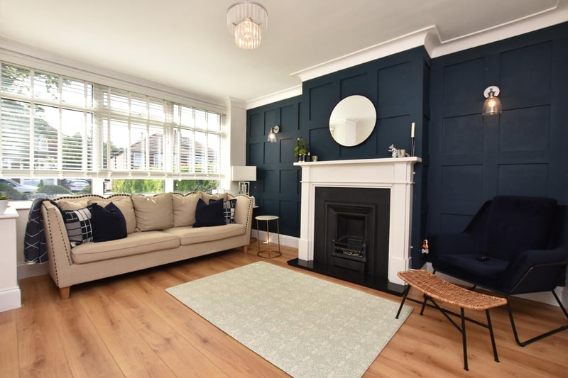 To the front of the property is well proportioned lounge. One wall has been stylishly panelled is a navy blue colour scheme which is complemented by the wide plank wood effect flooring