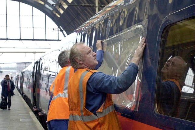 Temporary plastic sheeting is stuck over windows on a GNER train, the 15.05 from Leeds to Kings Cross.  The outer glass in five windows were smashed by stones and bricks thrown at the train by vandals in the Wakefield area.