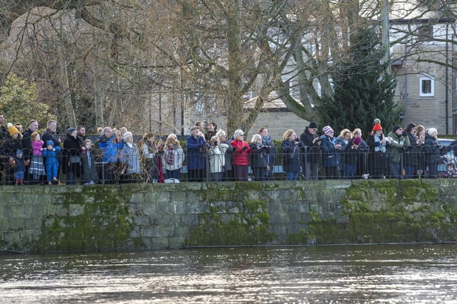 Crowds of people watch the hardy swimmers brave high water levels, a strong current and a water temperature of 6 degrees by taking part in the annual New Years Day Joe Town - Lilian Rickett Memorial Swim in the River Wharfe at Otley. Picture Tony Johnson