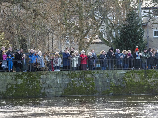 Crowds of people watch the hardy swimmers brave high water levels, a strong current and a water temperature of 6 degrees by taking part in the annual New Years Day Joe Town - Lilian Rickett Memorial Swim in the River Wharfe at Otley. Picture Tony Johnson