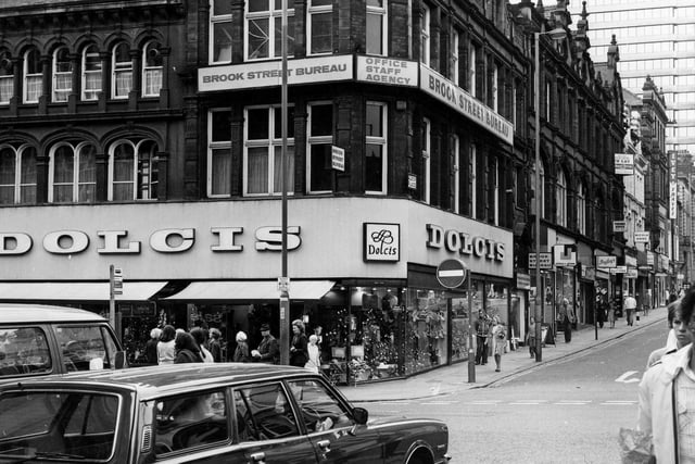 Looking up from King Edward Street to Briggate and the junction with Albion Place in April 1979. Dolcis shoe shop is on the corner of Briggate and Albion PLace and above, at number 17 Albion Place, is Brook Street Bureau, office staff agency. West Riding House is visible in the background.