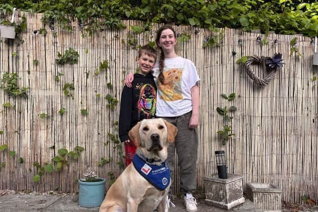 Oliver and Isabella Foster with trainee support dog Newton