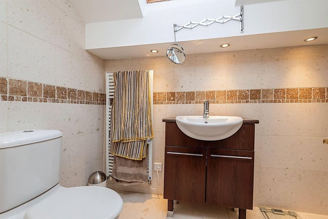 The stylish house bathroom has a bath with shower over and glass screen, pedestal wash hand basin, heated towel rail, tiled flooring and part tiled walls. On the second floor there is a further en-suite.