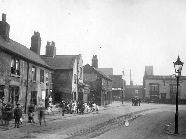 Church Street junction with Low Road showing Wellington Hotel in August 1929. There is a group of men in centre of the road and a gathering of children on the path and road outside properties.