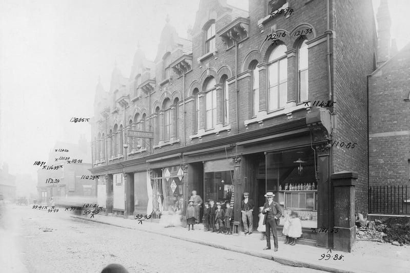 Waterloo Road in August 1904. In the centre of the photo, a pawn brokers sign with the name Hebden can be seen. This was no.31, business of John William Hebden. Next, to the right, was William Rogerson clothier at no.33. At no.35 was Mrs Rebecca Gill, running a dining room. At the right edge, the corner of the Wesleyan Chapel. A group of spectators stand in front of the shops.