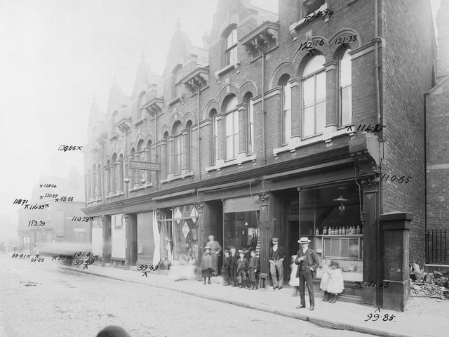 Waterloo Road in August 1904. In the centre of the photo, a pawn brokers sign with the name Hebden can be seen. This was no.31, business of John William Hebden. Next, to the right, was William Rogerson clothier at no.33. At no.35 was Mrs Rebecca Gill, running a dining room. At the right edge, the corner of the Wesleyan Chapel. A group of spectators stand in front of the shops.