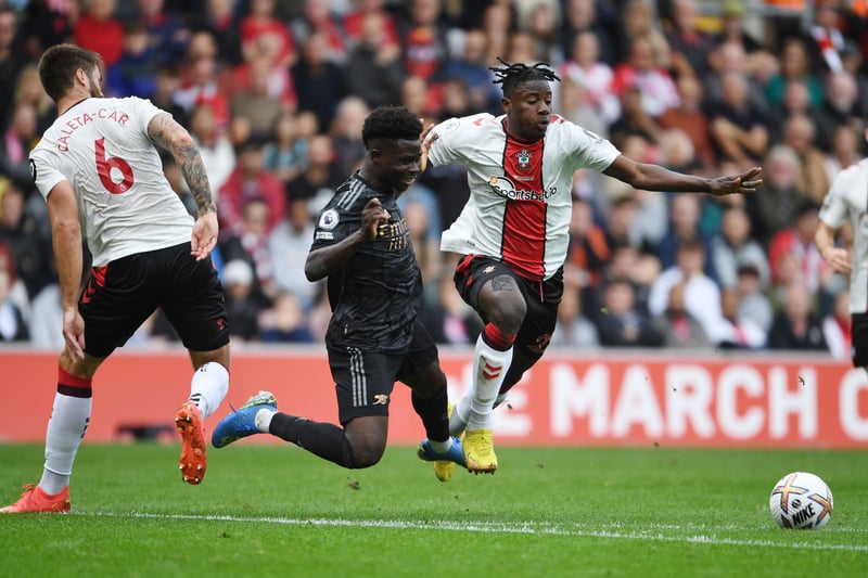 SOUTHAMPTON, ENGLAND - OCTOBER 23: Bukayo Saka of Arsenal challenged by Southampton defenders (L) Duje Caleta-Car and (R) Mohammed Salisu during the Premier League match between Southampton FC and Arsenal FC at Friends Provident St. Mary's Stadium on October 23, 2022 in Southampton, England. (Photo by Stuart MacFarlane/Arsenal FC via Getty Images)