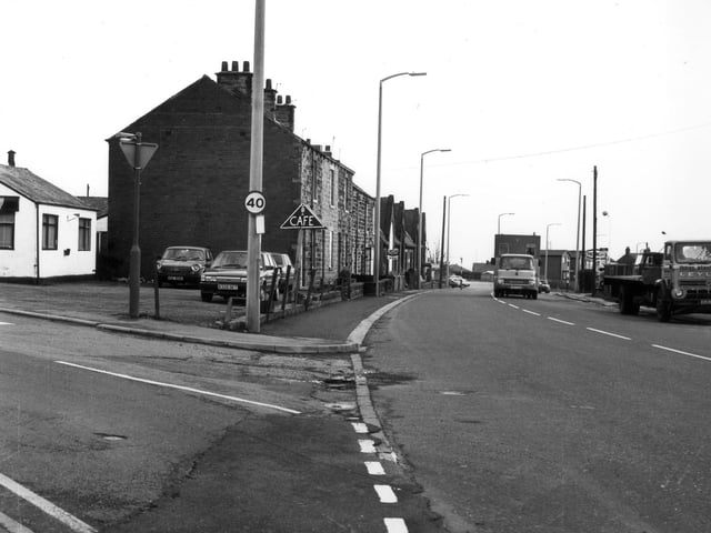 Bradford Road in East Ardsley, from the junction with Chapel Street, seen on the left, and looking south-east. On the left can be seen a small white building, in use as a cafe, and now a Chinese take-away restaurant. Beyond the parked cars are numbers 58 to 48 Bradford Road, and beyond them, the building of the former East Ardsley Boy's School, in use as a youth club from around the late 1960s, and demolished in the early 1990s. 