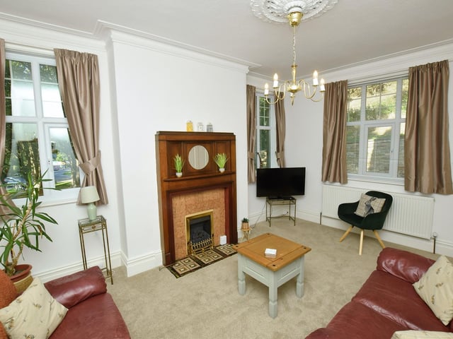 Three windows allow natural light to flood in to this room, with a central feature fireplace.