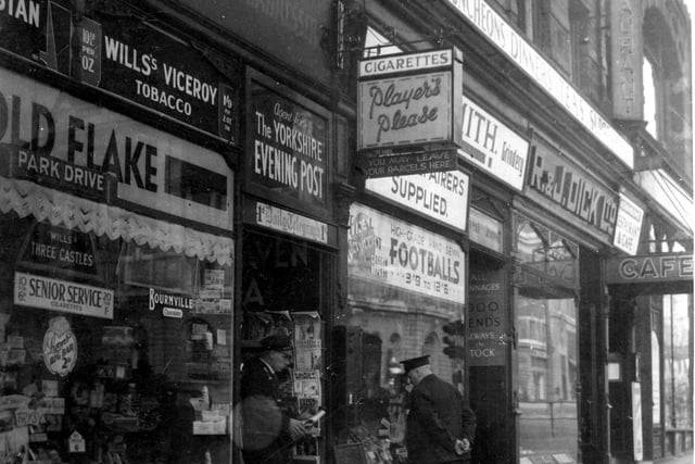 View looking up Eastgate with Charles Hardy, hairdressers and newsagents to front of the photograph. Signs and Newspaper boards are displayed on shop front and pavement outside. David Smith, Leather Merchant can be seen on the right at number 6. Pictured in September 1937.