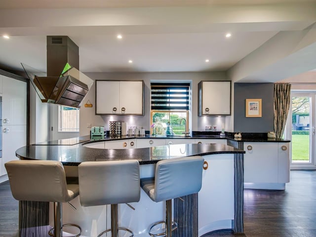 A sleek and stylish open kitchen has an adjoining dining area.