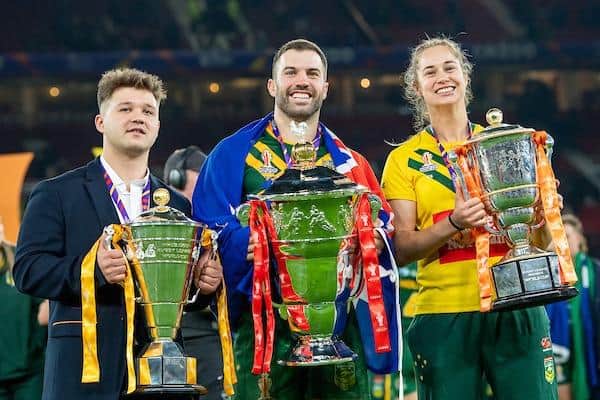 World Cup winning captains Tom Halliwell (England wheelchair), James Tedesco (Australia men) and Kezie Apps (Australia women) with their trophies on the pitch at Old Trafford. Picture by Allan McKenzie/SWpix.com.