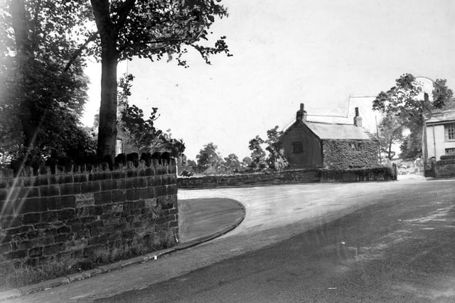 The junction of Spen Lane and Abbey Walk from the top of Abbey Walk in July 1950. The photograph has the proposed widening painted onto it to show how it will look. The ivy covered house is the Lodge. The white rendered house on the far right is the end of a row of cottages known as Hark to Rover.