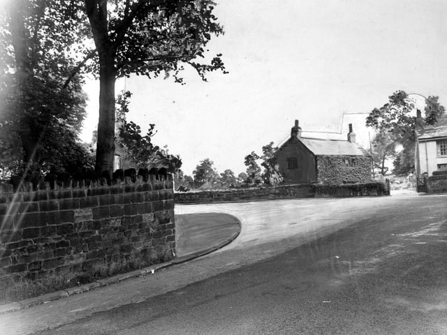 The junction of Spen Lane and Abbey Walk from the top of Abbey Walk in July 1950. The photograph has the proposed widening painted onto it to show how it will look. The ivy covered house is the Lodge. The white rendered house on the far right is the end of a row of cottages known as Hark to Rover.