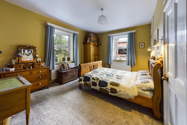 Two large windows bring plenty of natural light in to this bedroom.