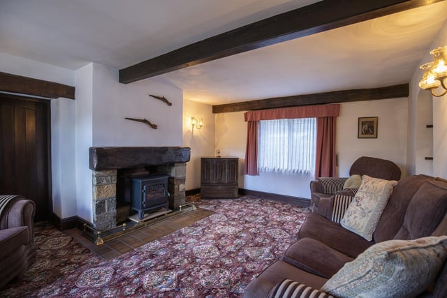 This sitting room has a solid fuel stove within a stone fireplace.