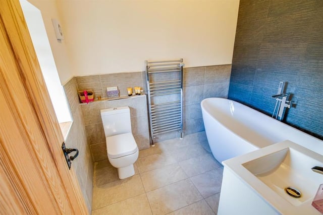 A bathroom with free standing bath and wash basin vanity unit.