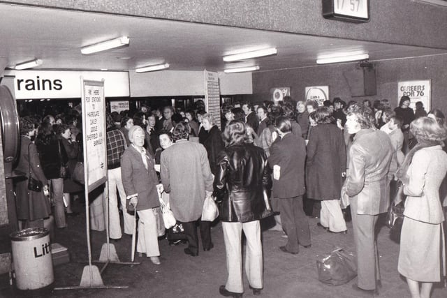 Passengers wait at barriers in Leeds City Station after a bomb alert in November 1975.