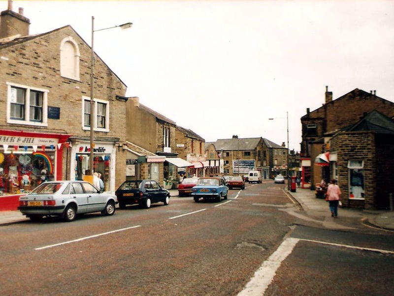 Pudsey Lowtown from the junction with Manor House Street, foreground, right. Old stone built shop and business premises occupy both sides of Lowtown. On the left is 'Jack & Jill' specialising in children’s wear. Adjacent is Homelife, and next to it the entrance to Booth's Yard.