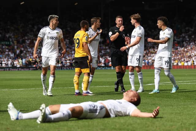 FLASHPOINT: Leeds United defender Rasmus Kristensen, front, lays poleaxed after being wiped out by Wolves keeper Jose Sa as referee Robert Jones, centre, looks on during Saturday's Premier League clash at Elland Road. Photo by Marc Atkins/Getty Images.