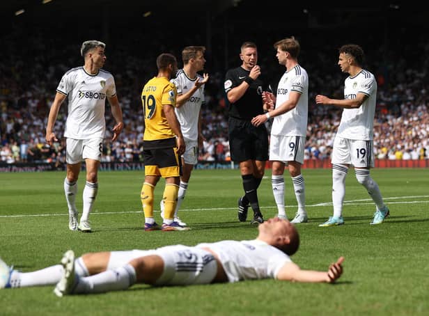 FLASHPOINT: Leeds United defender Rasmus Kristensen, front, lays poleaxed after being wiped out by Wolves keeper Jose Sa as referee Robert Jones, centre, looks on during Saturday's Premier League clash at Elland Road. Photo by Marc Atkins/Getty Images.