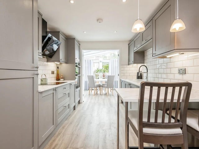 The kitchen diner has an extensive range of modern cupboard and drawer units, including an inset white single drainer sink unit within the base cupboard, laminate work surfaces, tiled surround, electric induction hob and an electric double oven.