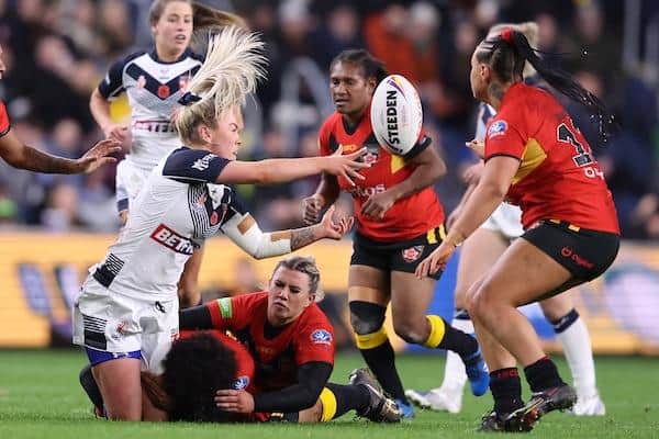 Rhinos' Georgia Roche offloads during England's win over Papua New Guinea. Picture by John Clifton/SWpix.com.