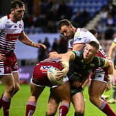 Harry Newman gets an offload away during Leeds Rhinos' defeat at Wigan Warriors. Picture by Olly Hassell/SWpix.com.