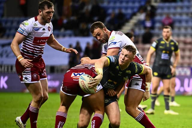 Harry Newman gets an offload away during Leeds Rhinos' defeat at Wigan Warriors. Picture by Olly Hassell/SWpix.com.