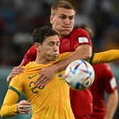 HALF A GAME: For Leeds United's Rasmus Kristensen, back, pictured challenging Australia's Craig Goodwin. Photo by PAUL ELLIS/AFP via Getty Images.