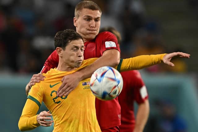 HALF A GAME: For Leeds United's Rasmus Kristensen, back, pictured challenging Australia's Craig Goodwin. Photo by PAUL ELLIS/AFP via Getty Images.