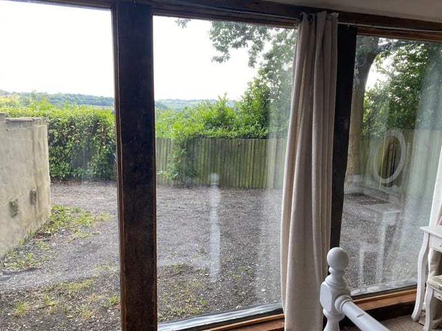 The first bedroom has a glass-fronted view over the woodland.