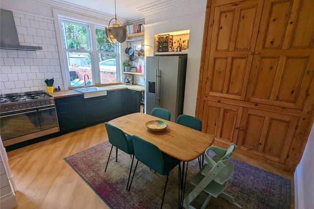 To the rear is a sociable dining kitchen with fitted storage units, which also has a large original cabinet which has been fitted out with bespoke storage compartments.