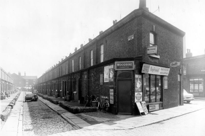 Hazelhead Place from the junction with Albury Road. On the junction is W. & B. Barrett, Newsagent selling sweets and tobacco. There are numerous advertisements outside the shop including ones for 'Boyfriend' magazine and 'Cherry Blossom Shoe Polish'. Hazelhead Street can be seen at the far end of Hazelhead Place. Albury Terrace can be seen on the right.