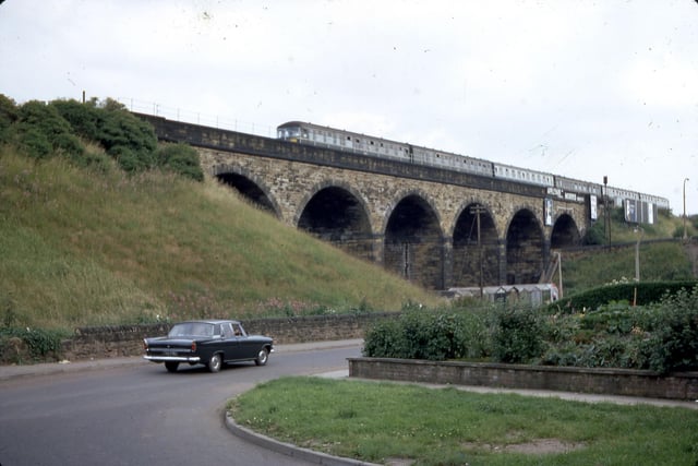 The railway viaduct from the bottom of Churwell Hill in July 1968. A diesel train crosses the six-arch viaduct while a car can be seen travelling on Old Road.