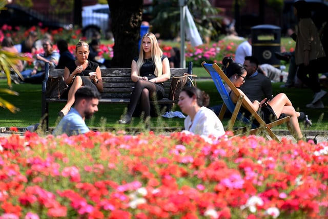 People sit out and enjoy the sunshine at Park Square, Leeds.