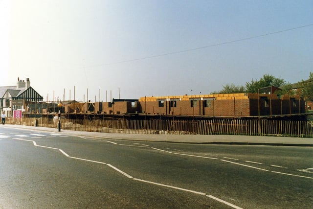 Selby Road showing the construction site for the new Halton Branch Library, part of a £1 million shopping centre development. The new library would soon replace the old branch which is still standing on the left of the picture, in front of the Travellers Inn public house. Pictured in April 1987.