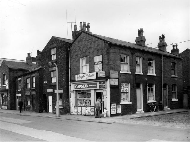 Beza Street in July 1961. On the left is a grocers business run by Marie Steel. The newsagents shop is at the corner with Garden Place was run by J R Armstrong.