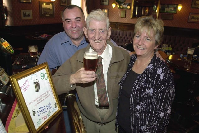 Regular Tommy Spurr stands in the same place as he has done for the last 72 years at the White Cross pub. He is pictured with landlord Colm and Sue O'Neill in October 2003.