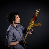 Jamie Hood, Conservation and Technical Manager with the golden Iraqi 'Tabuk' AK-47 style assault rifle, associated with the Hussein family. Photo: Tony Johnson.