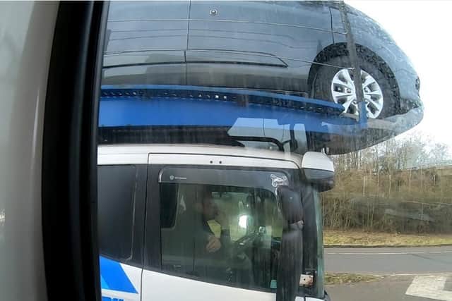 A driver is caught on camera using just his elbow to steer a car transporter on a busy motorway. Picture: National Highways/PA Wire